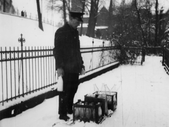 1977-3235 Een melkboer ter hoogte van Honingerdijk en Oostzeedijk. Op de achtergrond de Sint-Lambertuskerk aan de Hoflaan.